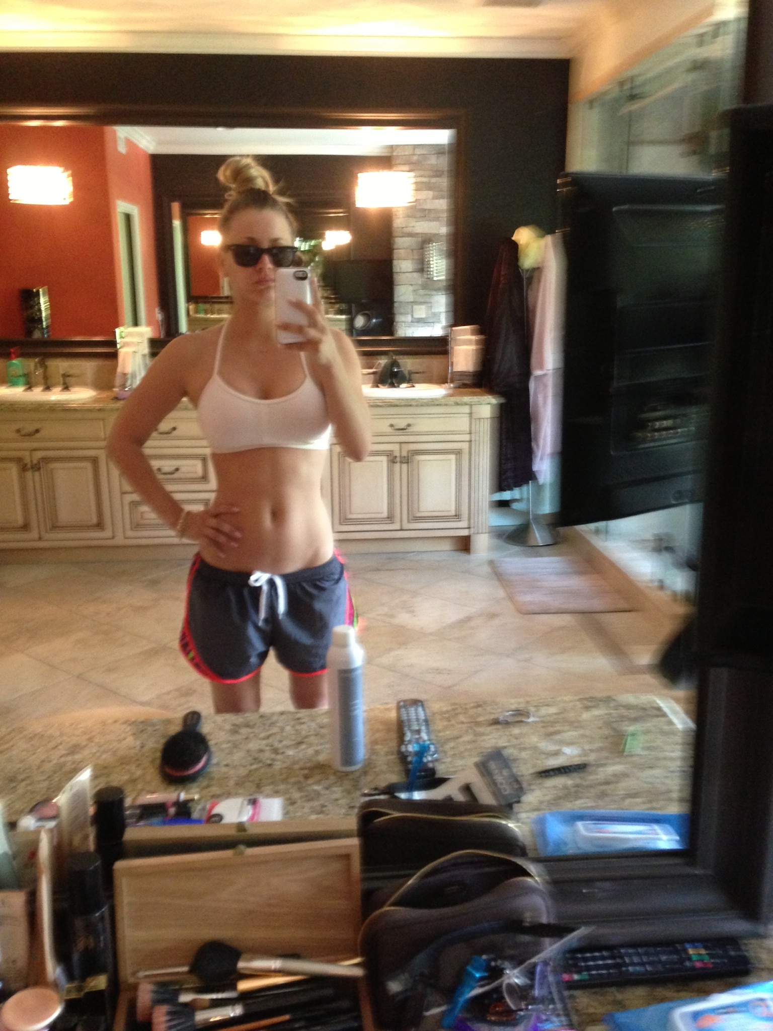selfie of kaley cuoco showing off her fit body in sports bra and shorts
