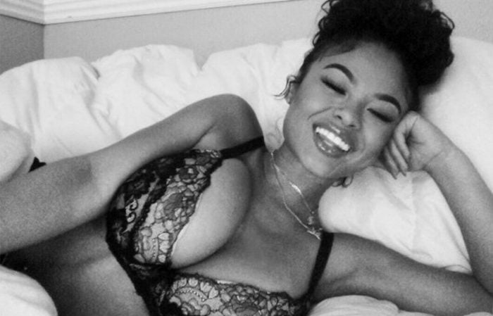 The model India Love wearing a black lace bra in bed