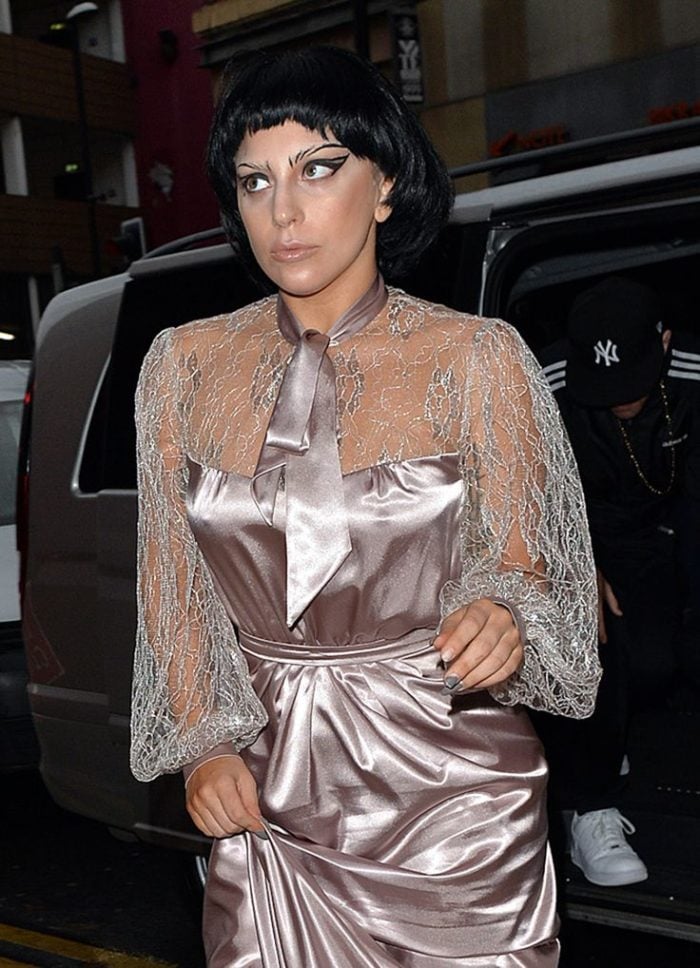 crazy shiny outfit on a short black haired Lady Gaga with pokies visible