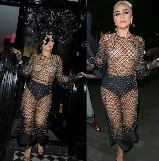 Lady Gaga in a black fishnet dress wearing a black feather hat