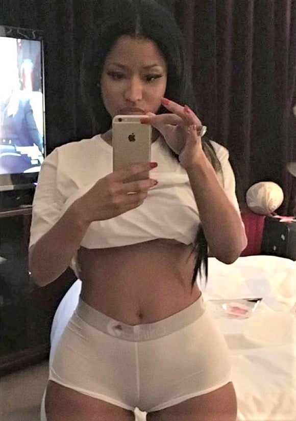 Hot photo of Nicki Minaj taking a selfie in the mirror with tight short shorts on and white crop top showing her nice body