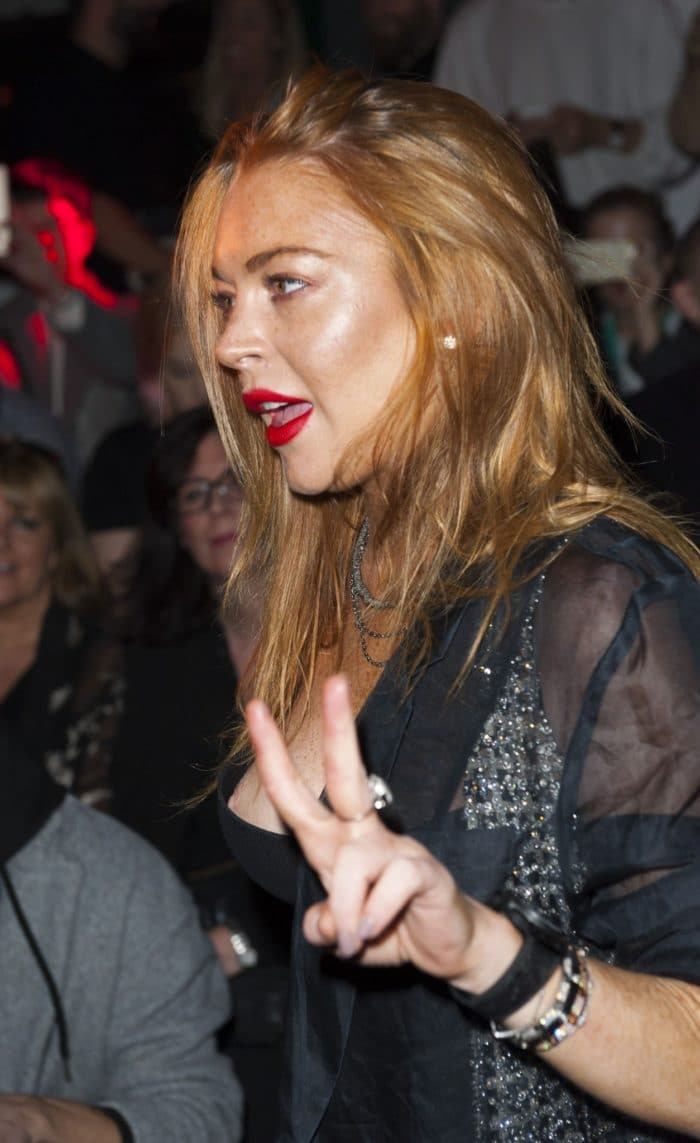 London Fashion Week photo of Lindsay Lohan and her nip-slip while she is giving a peace sign