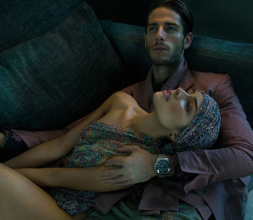 Treats Magazine modeling photo of Olivia Culpo in head scarf with man holding her on couch looking up