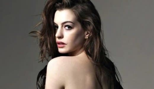 gorgeous celebrity anne hathaway poses topless and is looking back at the camera with a sexy look
