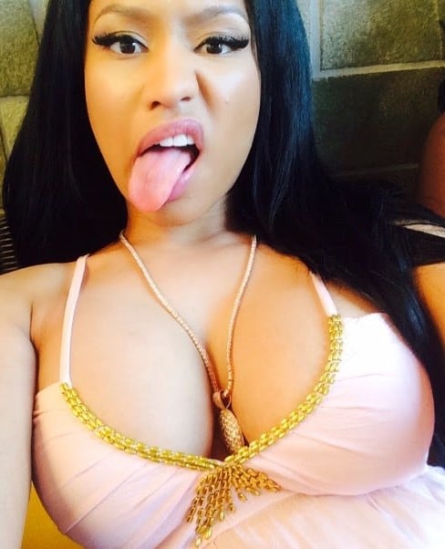selfie photo of Nicki Minaj sticking her tongue out with cleavage exposed in pink top