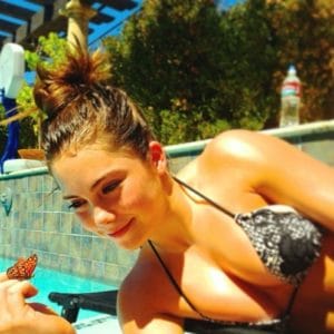 Instagram photo of McKayla Maroney in a bikini top with her boobs coming out and a butterfly on her hand