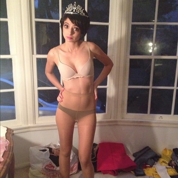 Kate Micucci standing in front of window in her underwear with a crown on her head