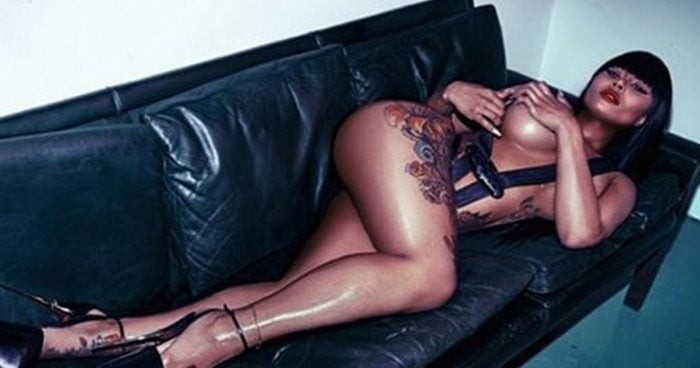 Blac Chyna laying on a black couch naked