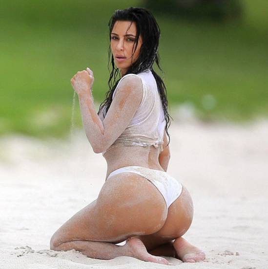 Kim Kardashian in a white bikini covered in sand ass cheeks visible