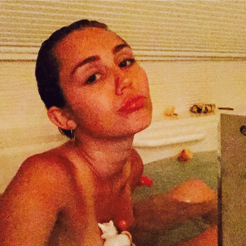 Miley Cyrus pouting in a bathtub naked