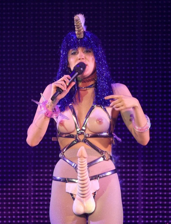 Miley Cyrus wearing a purple wig on stage