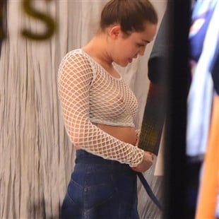 Miley Cyrus wearing a white mesh shirt nipples visible