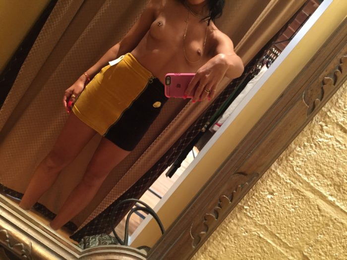 Sami Miro wearing a yellow and black skirt topless