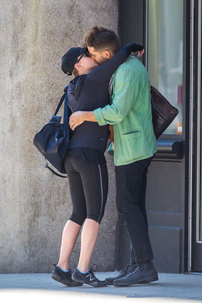 Scarlett Johansson and husband hug goodbye and she is wearing yoga pants