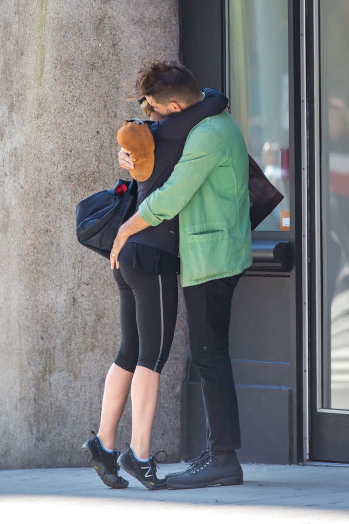 Scarlett Johansson is wearing yoga pants and she hugs her husband goodbye