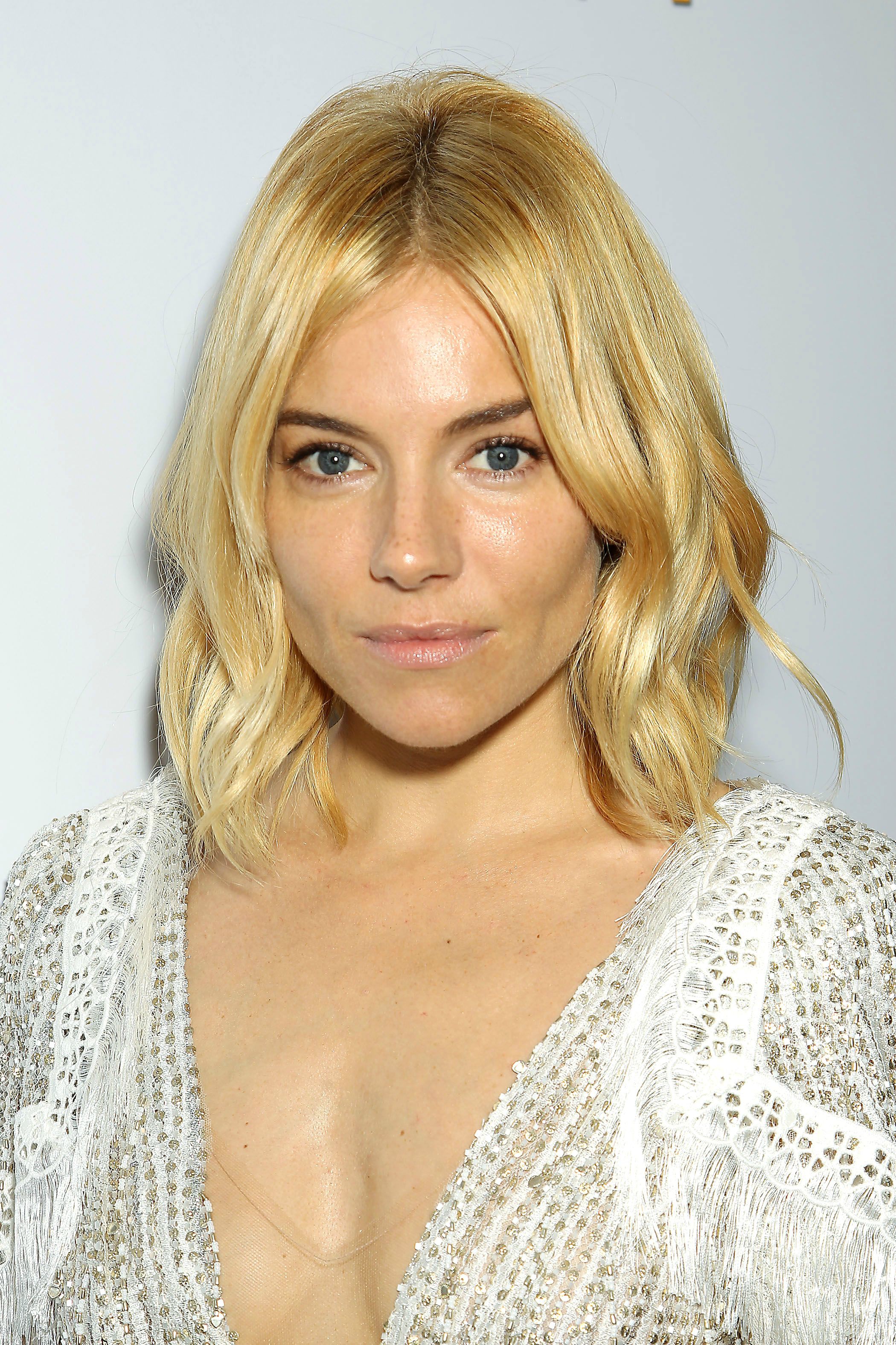Sienna Miller in a low cut white dress exposing cleavage