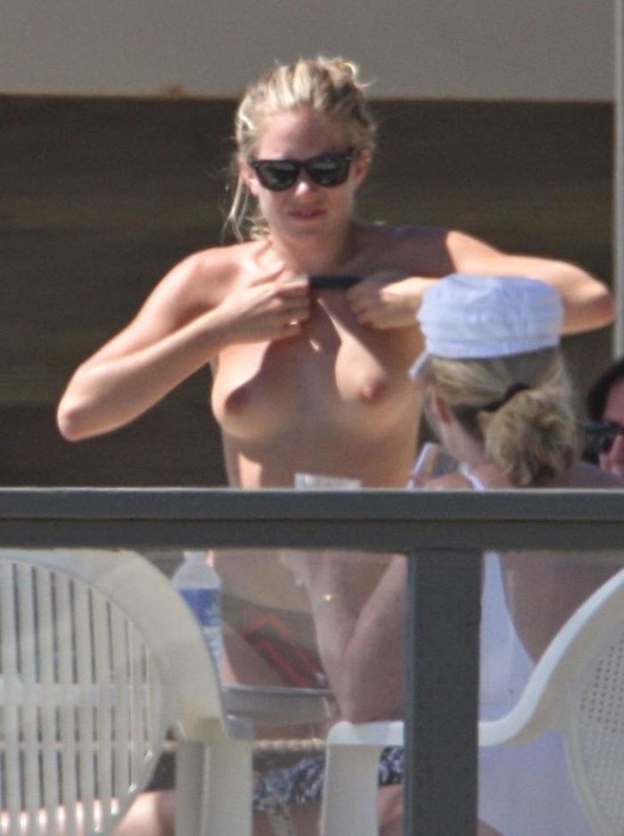 Sienna Miller on a balcony with no top on