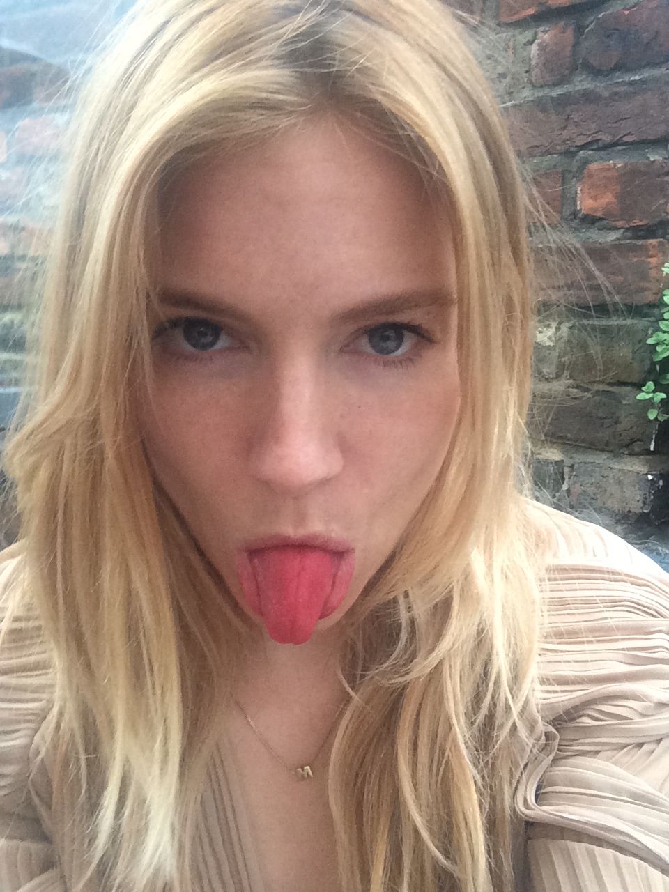Sienna Miller taking a selfie with her tongue sticking out