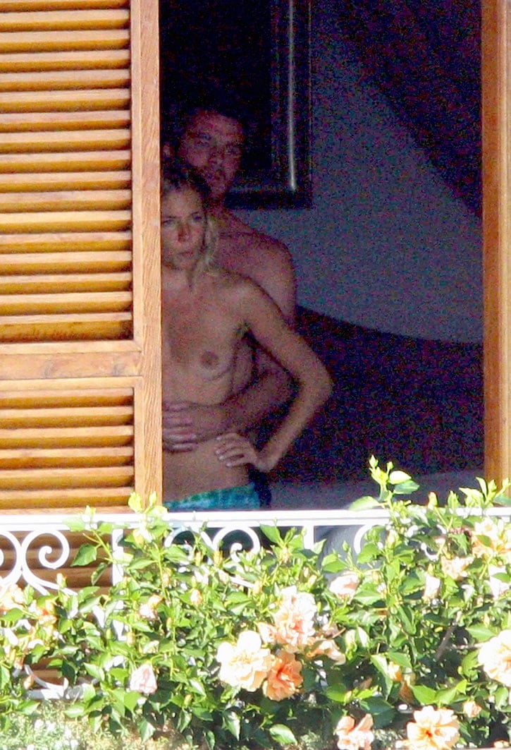 Sienna Miller with boyfriend topless on a balcony in the doorway