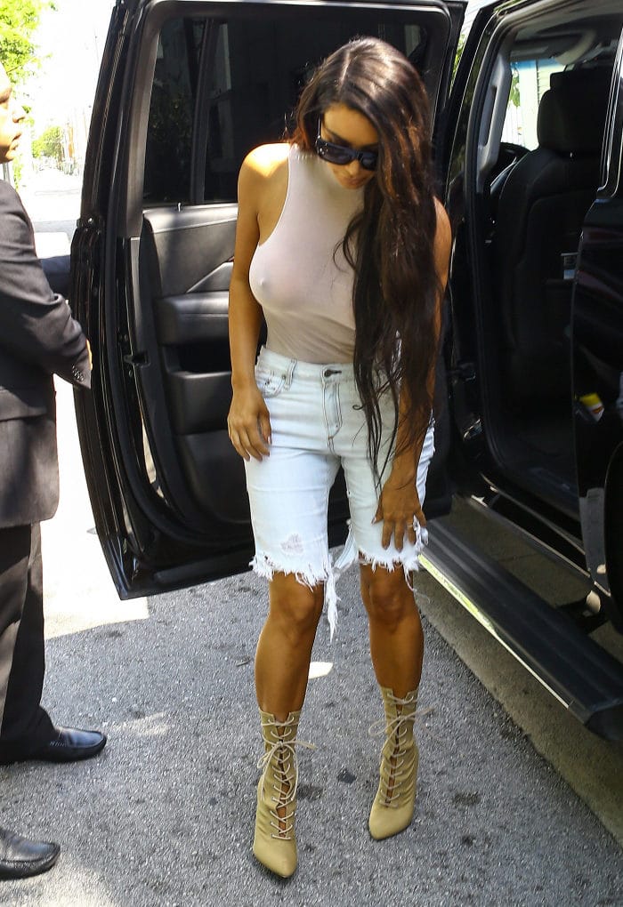 Kim Kardashian in heels getting into her limo with nipples revealed in white top