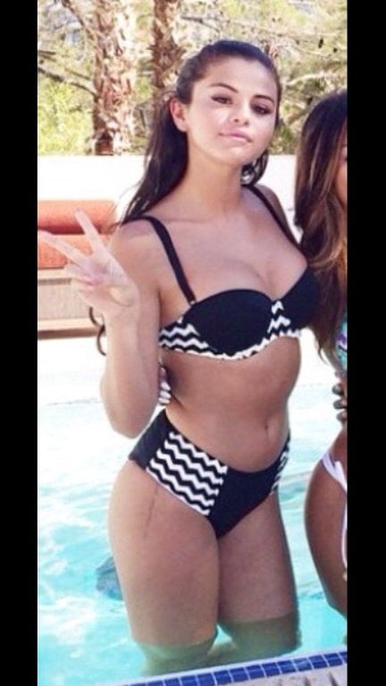 Selena Gomez in bikini making peace sign
